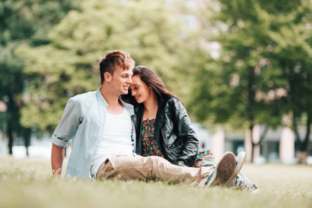 istock couple resting and flirting in the park 916803960