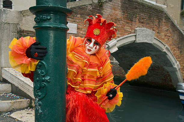 weibliche maske mit roten harlekin kostüm zum karneval in venedig - jester harlequin carnival venice italy stock-fotos und bilder