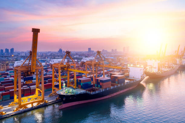 istock Containers yard in port congestion with ship vessels are loading and discharging operations of the transportation in international port.Shot from drone. 916806742