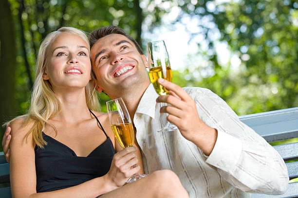Young happy couple celebrating with champagne, outdoors stock photo