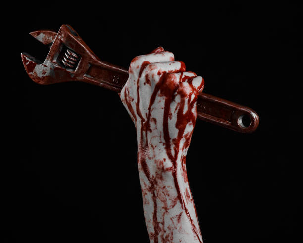 istock Halloween theme: bloody hand holding a big wrench on a black background 916818862