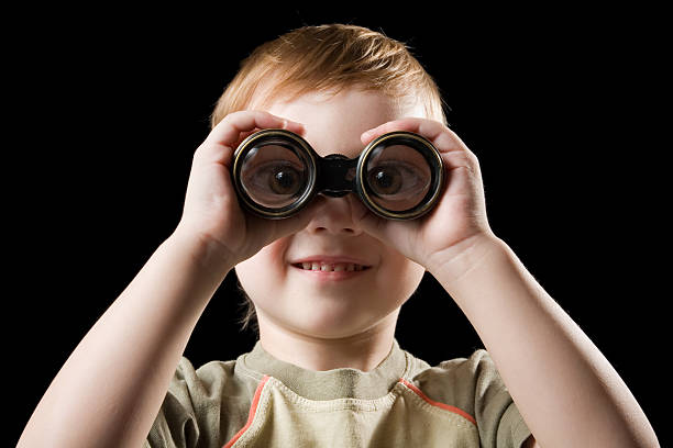 The child watching with binoculars. stock photo