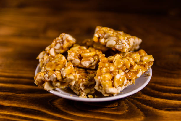 istock Ceramic plate with peanut brittles on wooden table. 916821986