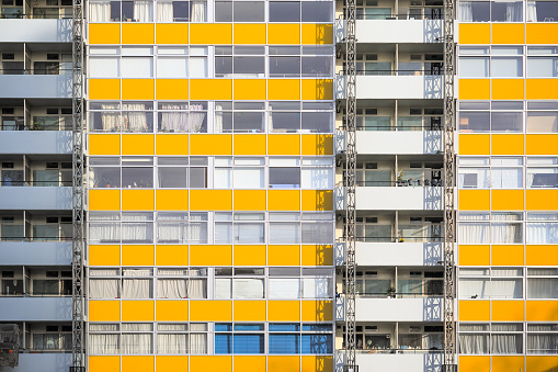 Facade of a council housing block faced with panels in yellow colour in London