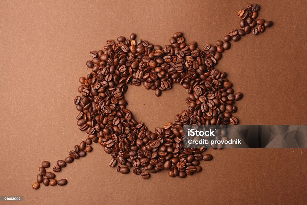 Coffee beans heart with arrow на Коричневый фон - Стоковые фото Близость роялти-фри