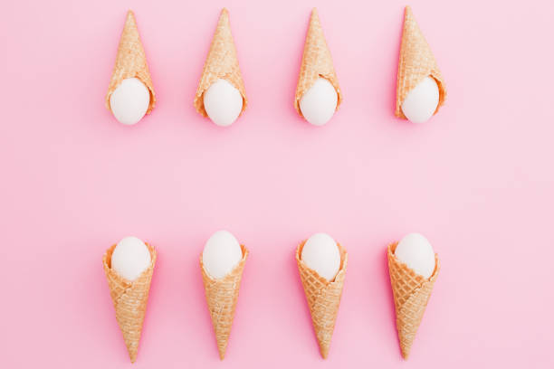 istock Easter white eggs in waffle cones on pastel pink background. Top view, Flat lay. Easter holiday concept. 916830106