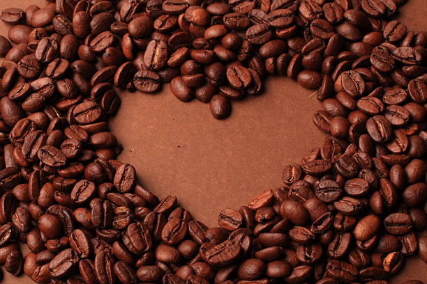 Coffee beans heart over brown background stock photo