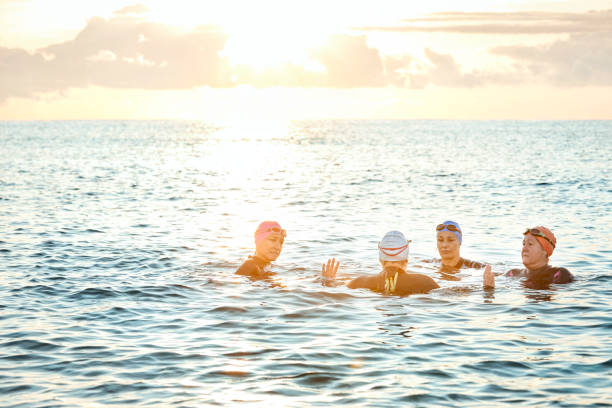 istock Female friends talking while swimming in sea 916830390