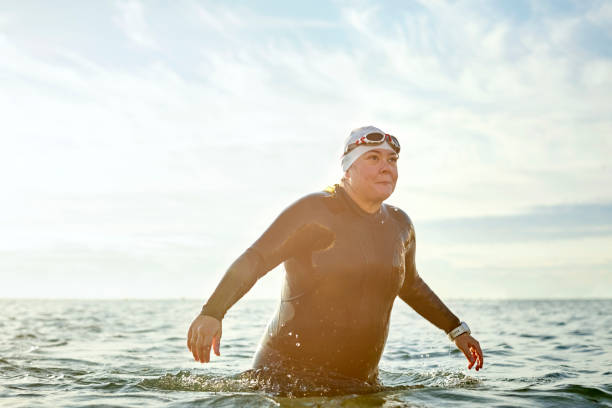 istock Female swimmer walking in sea 916830550