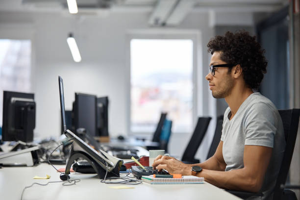 istock Businessman using laptop at desk in office 916837050