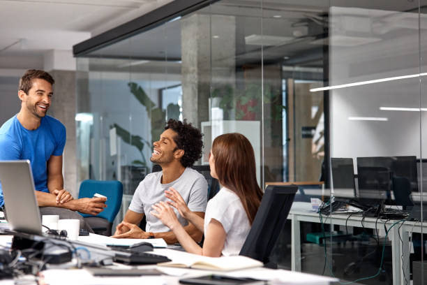 istock Happy business people discussing at desk in office 916837230