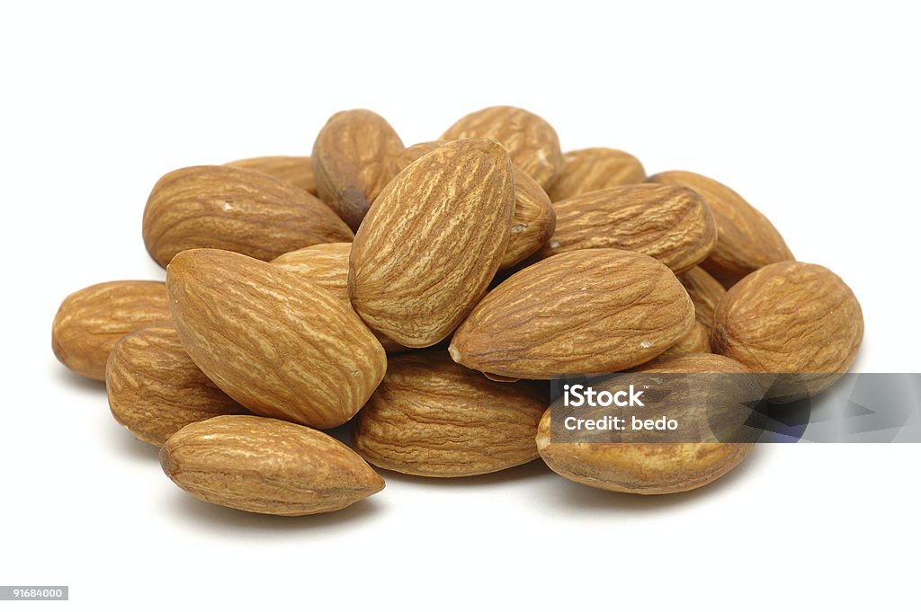 Pile of ripe brown almonds on a white background Pile of almonds in isolated white background Almond Stock Photo