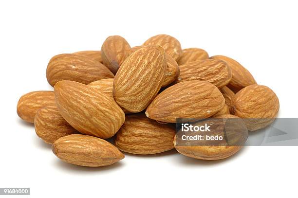 Pile Of Ripe Brown Almonds On A White Background Stock Photo - Download Image Now - Almond, Brown, Close-up