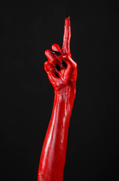istock Red Devil's hands, red hands of Satan, Halloween theme, black background, isolated 916840350