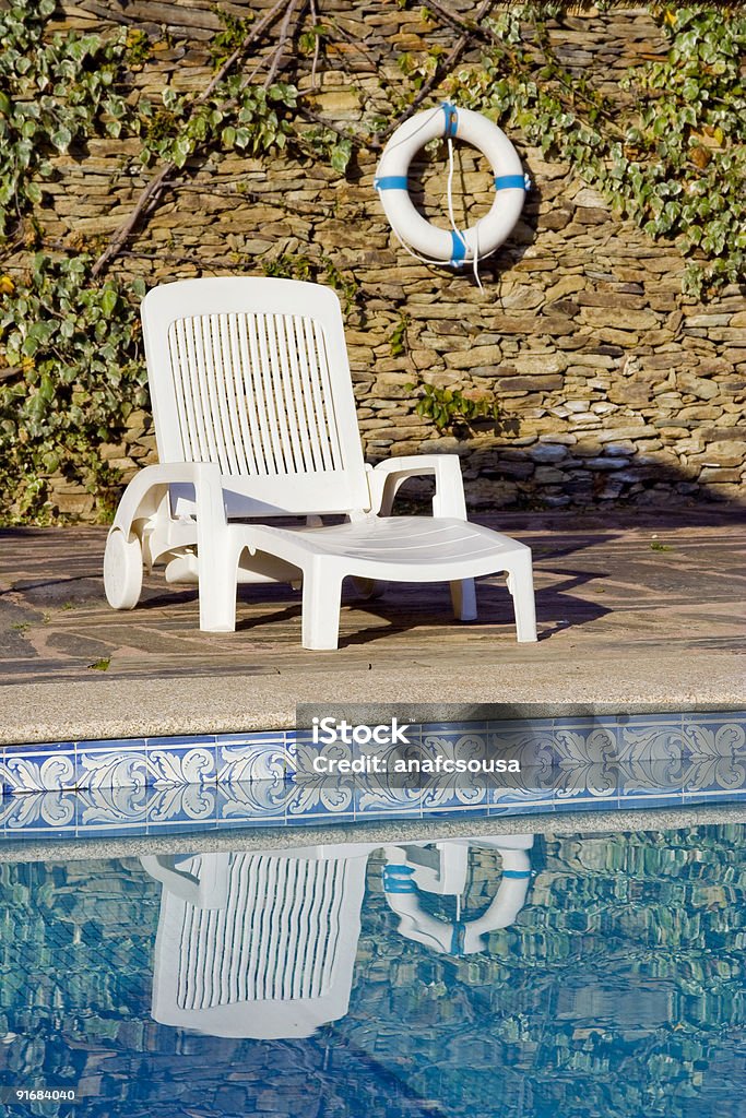 buoy and  white deckchair near the swimming pool  Armchair Stock Photo