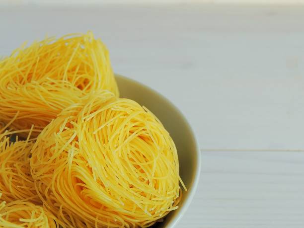 istock Raw pasta, macaroni nests in a bowl. 916840460