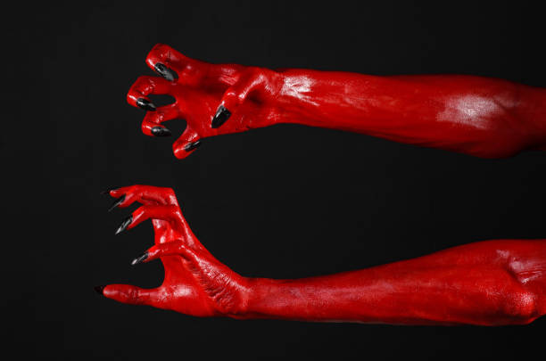 istock Red Devil's hands, red hands of Satan, Halloween theme, black background, isolated 916840560