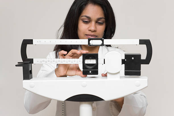 doctor adjusting weight scale stock photo