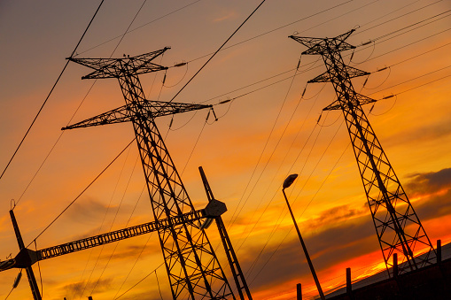 High voltage wire electrical energy plant producing electricity at sunset