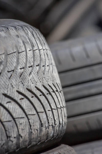 istock Pile of used rubber tyres in a garage back yard. 916841234