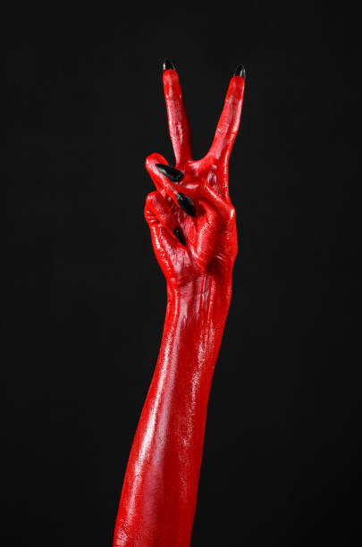 istock Red Devil's hands, red hands of Satan, Halloween theme, black background, isolated 916844116