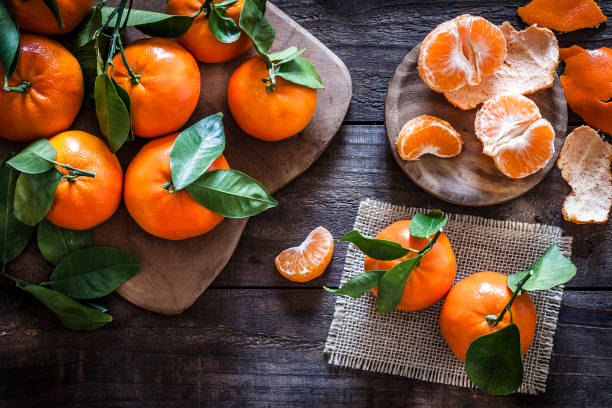 mandarinas frescas orgánicas en mesa de madera rústica - mandarina fotografías e imágenes de stock
