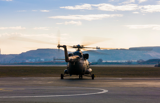 An armed guard looks up at the MV-22 Osprey aircraft while patrolling the deck of USS Tripoli (LHA 7) of the US Navy docked at Garden Island, Sydney Harbour.  This image was taken from Mrs Macquarie's Chair on an afternoon in Spring.