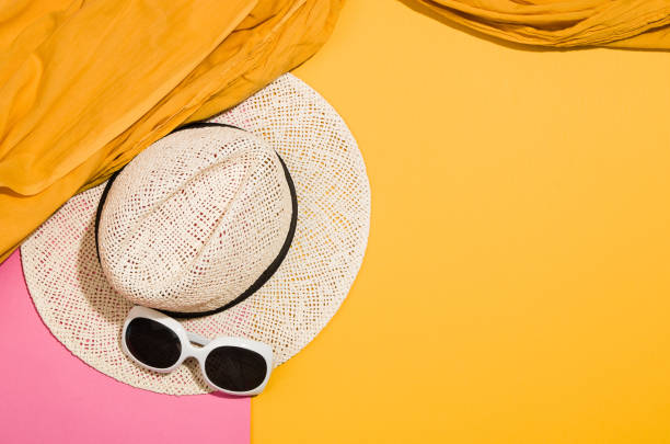 Woman's accessories flat lay on colorful background. Top view. Pink and yellow pastel colors with copy space around products. Horizontal image or photograph.