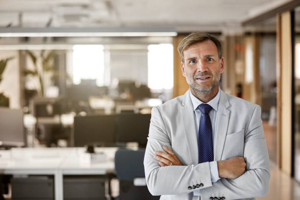 istock Businessman standing with arms crossed in office 916849048