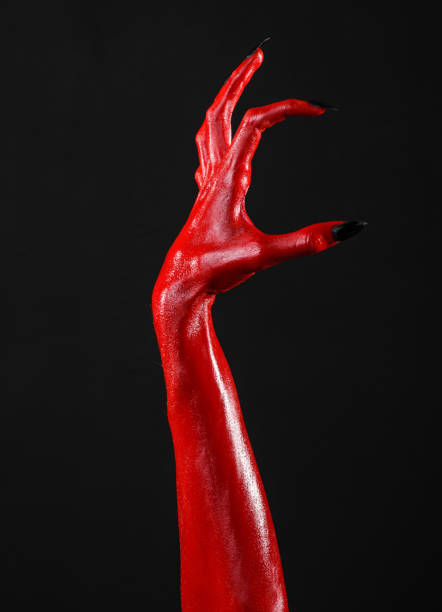 istock Red Devil's hands, red hands of Satan, Halloween theme, black background, isolated 916851688