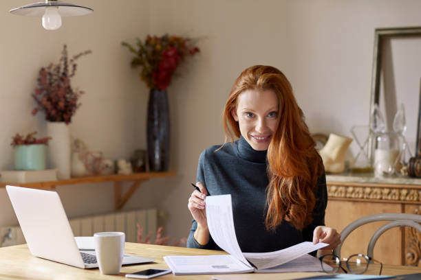 istock Portrait of smiling woman with documents at table 916852260