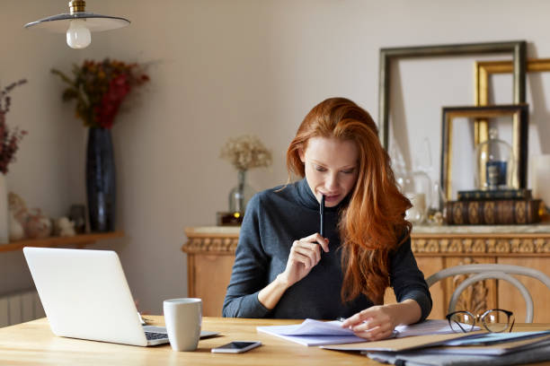 istock Thoughtful woman reading documents at home 916852286