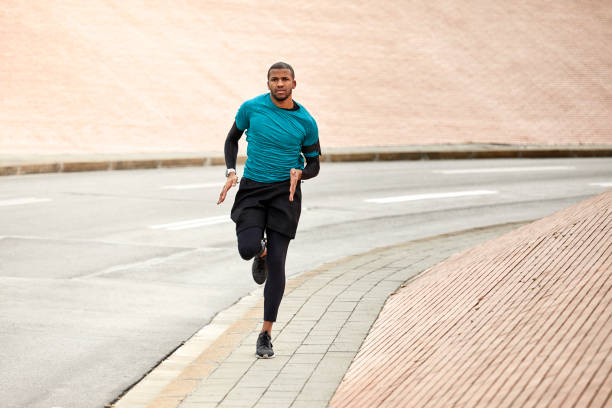 istock Dedicated man running on roadside in city 916858816