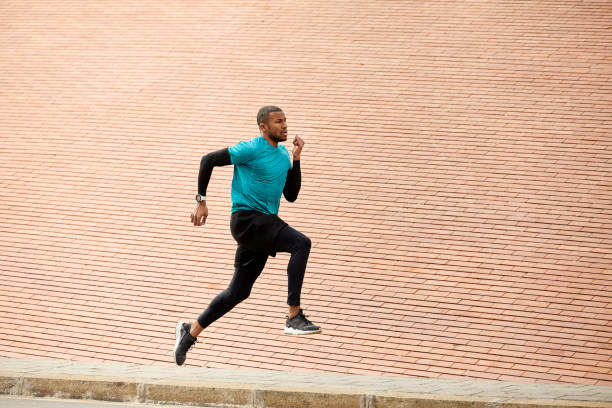 istock Dedicated man running on roadside in city 916858824