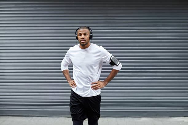 istock Sporty man with hands on hips against shutter 916859196