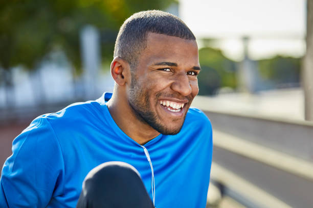 istock Cheerful man looking away while sitting at park 916859620