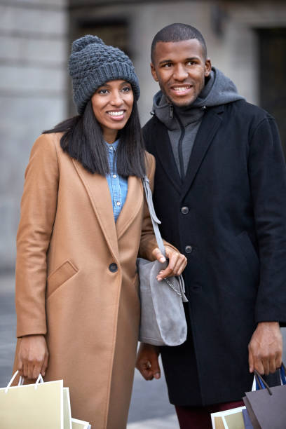 istock Happy couple looking away while holding bags 916862378