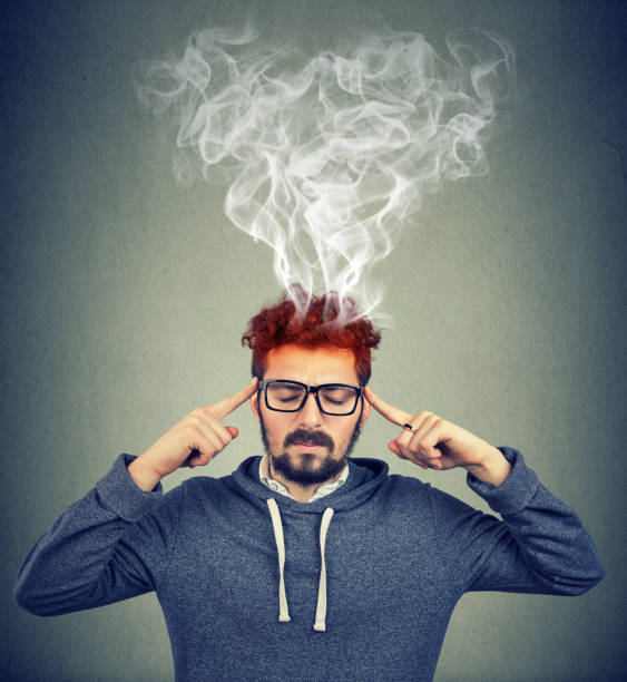 istock man thinking very intensely having headache with steaming coming out 916863490