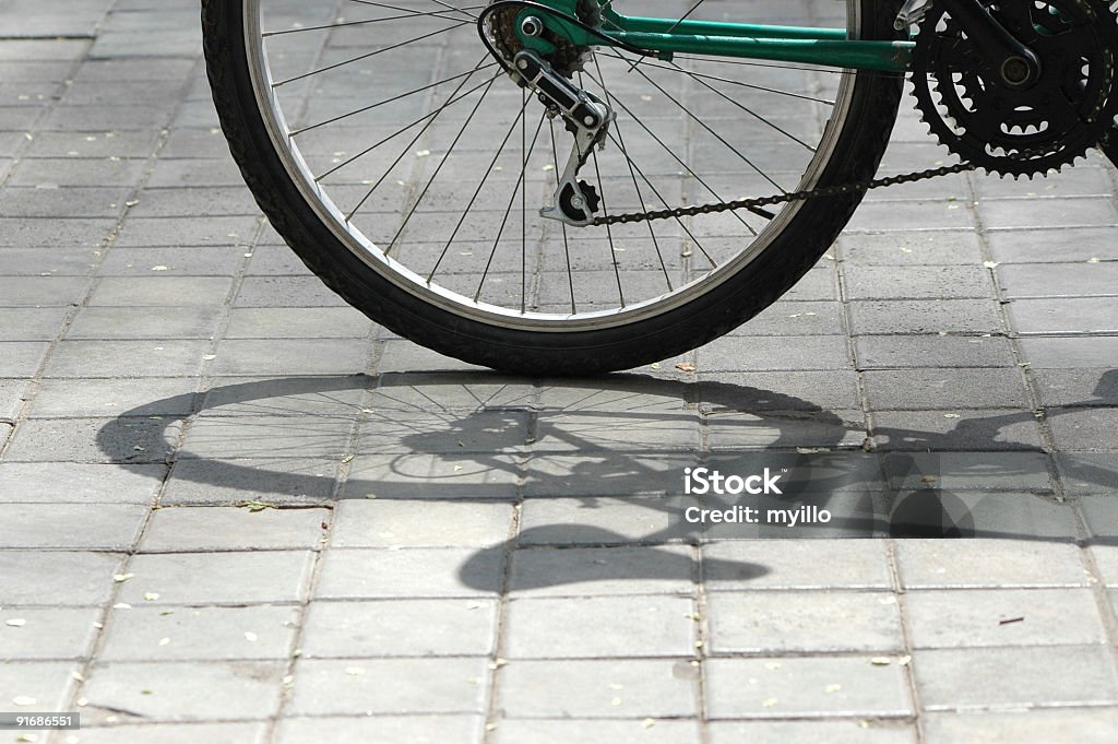 bicycle detail wheel with gear of bicycle and the shadow on the sidewalk.(see some similar pictures clicking the images) At The Edge Of Stock Photo