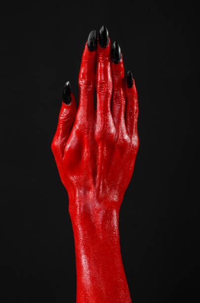 istock Red Devil's hands, red hands of Satan, Halloween theme, black background, isolated 916867368