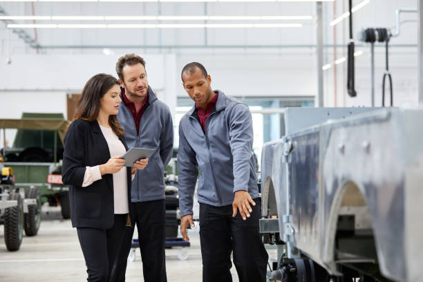 istock Engineer showing incomplete car to colleagues 916867474