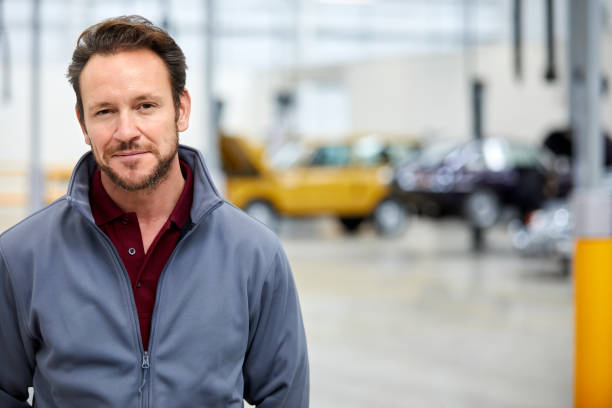 Portrait of confident engineer in car plant Portrait of confident engineer in car plant. Male technologist is in automobile industry. He is in jacket at factory. car portrait men expertise stock pictures, royalty-free photos & images