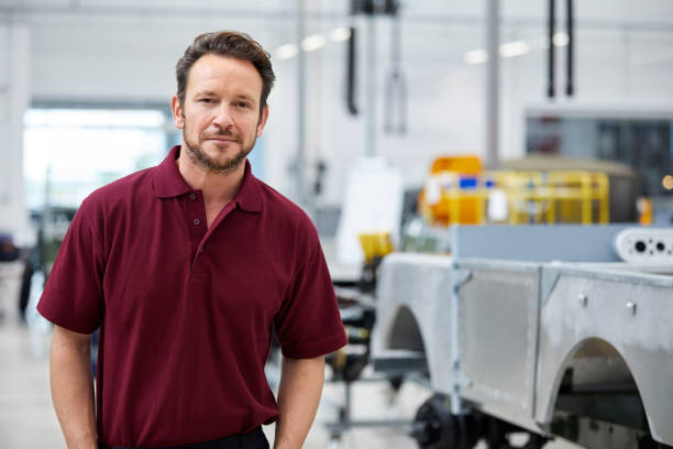 istock Mid adult engineer standing in automobile industry 916867842
