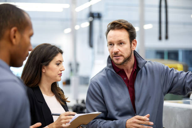 istock Engineer discussing with manager in car factory 916867888