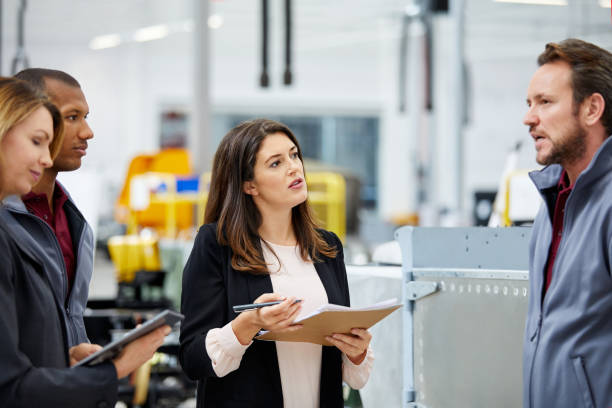 istock Manager discussing with engineers in car factory 916867900