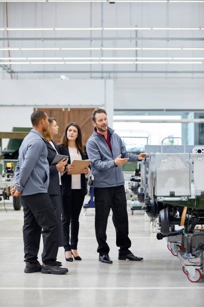 istock Male engineer showing car frame to supervisors 916867916