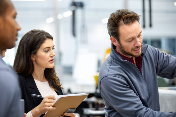 istock Engineer discussing with manager in car factory 916867930