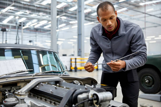 istock Male engineer checking oil with dipstick by car 916868068