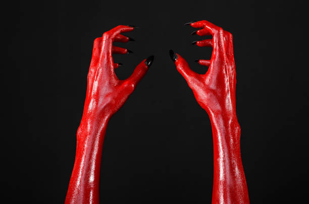 istock Red Devil's hands, red hands of Satan, Halloween theme, black background, isolated 916868562