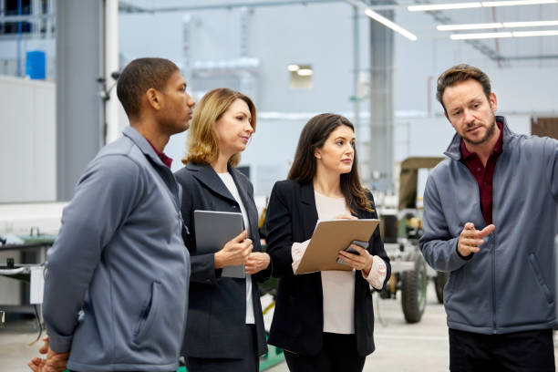 istock Engineer discussing with inspectors in car factory 916868914